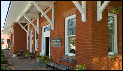 Under the roof overhang, a bench in the shade